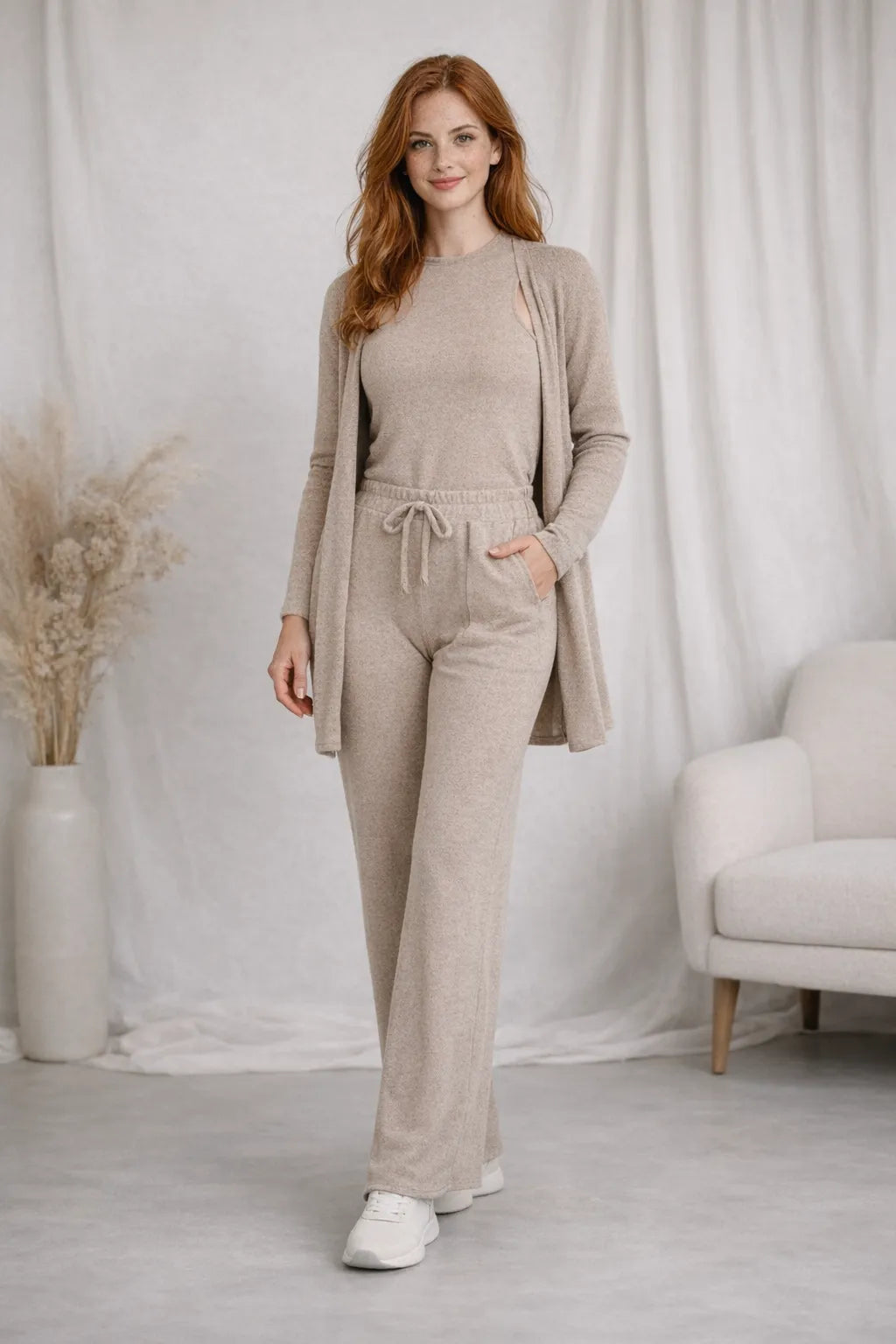 Mulher de frente usando Conjunto feminino lanzinha 3 peças bege  com calça pantalona cintura alta e blusa manga longa e casaco.